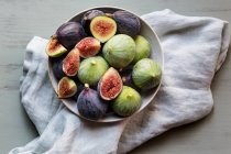 Тарелка свежих спелых инжиров на кухонном столе — стоковое фото