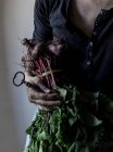 Persona irriconoscibile in possesso di mazzo di barbabietole e chiave vintage in mano — Foto stock