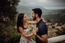 Loving couple embracing while standing against rural valley — Stock Photo