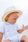 Vista frontal de um bebê na praia com um chapéu — Fotografia de Stock