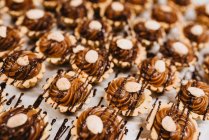 Set primo piano di deliziosi pasticcini con crema di caramello dolce e noci disposti su carta pergamena — Foto stock