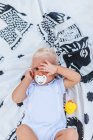 Retrato de um bebê loiro com expressão de sono — Fotografia de Stock