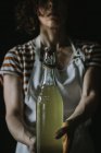 Recadré de femme tenant bouteille de cidre de sureau — Photo de stock