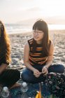 Porträt eines schönen asiatischen Mädchens an einem Tag am Strand mit ihren Freunden, die Sonne hinter sich — Stockfoto