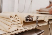 Máquina Shabby rolando massa macia fresca para preparação de pastelaria na cozinha da padaria profissional — Fotografia de Stock