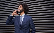 Afro-americano homem falando por telefone perto da parede — Fotografia de Stock