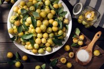 Frische Mirabellenfrüchte aus der gelben Pflaume in einer Schüssel auf einem Holztisch. Zubereitung von Pflaumenmarmelade — Stockfoto