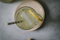 Top view of delicious elderflower lemonade in glass with ice and slice of lemon — Stock Photo