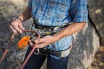 Cropped image of climber preparing his equipment to start climbing — Stock Photo