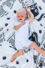 Blick von oben auf ein blondes Baby, das auf einer Decke weint — Stockfoto