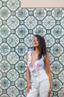 Mulher linda pacífica na roupa da moda em pé ao lado de azulejos parede exótica na rua cênica — Fotografia de Stock