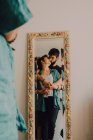 Відбиття ніжної пари поцілунків у високому прикрашеному дзеркалі — стокове фото