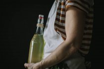 Side view of woman with bottle of elderflower beverage — Stock Photo