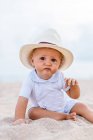 Вид спереду дитини на пляжі з капелюхом — стокове фото