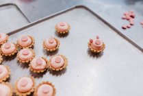 Kleine Desserts mit Schweineohren und Schnauze auf Blech in Bäckerei — Stockfoto
