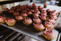 Металевий піднос зі смачною свинячою випічкою, розміщеною на стійці у професійній пекарні — стокове фото