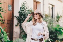 Stilvolle entspannte Frau, die durch eine Stadt voller Pflanzen läuft — Stockfoto