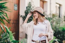 Stilvolle entspannte Frau, die durch eine Stadt voller Pflanzen läuft — Stockfoto