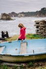 Donna in vecchio blu sulla riva del mare lavaggio da onde schiumose — Foto stock