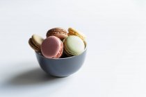 Ciotola di macaron freschi colorati su sfondo bianco — Foto stock