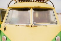 Bright retro minibus with round headlights on beach — Stock Photo