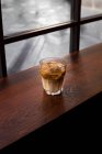 Von oben Tasse frischer kalter Eiskaffee auf Holztisch im Café serviert — Stockfoto