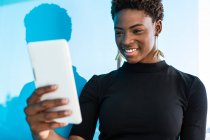Coole afrikanisch-amerikanische kluge Frau macht Selfie auf blauem Hintergrund — Stockfoto