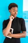 Cool African American smart woman standing near blue background — Stock Photo