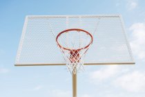 Outdoor basketball net in court against blue sky from below. — Stock Photo