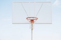 Cesta líquida na quadra de basquete ao ar livre contra o céu azul . — Fotografia de Stock