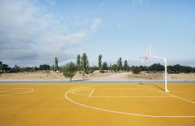 Cancha deportiva amarilla de baloncesto al aire libre . - foto de stock
