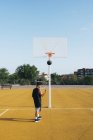 Jovem celebrando pontuação enquanto joga no campo de basquete amarelo ao ar livre . — Fotografia de Stock