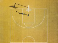 Vue aérienne de l'homme jouant au basket sur un terrain extérieur jaune . — Photo de stock