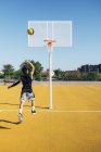 Junger Mann spielt auf Basketballplatz im Freien. — Stockfoto