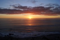 Vista a la playa arenosa y rocosa y al mar en las puestas de sol de la isla canaria. - foto de stock
