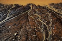 Von oben fließt abstrakter dunkler Boden mit schmutziger Pfütze und tropfendem rostigen Wasser — Stockfoto