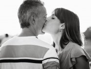 Mulher beijando homem feliz ao ar livre — Fotografia de Stock