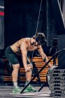 Homem muscular fazendo exercício na máquina de parte superior do corpo no clube de esporte moderno — Fotografia de Stock