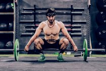 Strong and athletic man doing barbell workout in modern gym - foto de stock