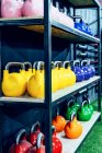 Set di kettlebell colorati sugli scaffali del moderno centro benessere — Foto stock