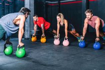 Les gars forts athlétiques faisant de l'exercice avec le poids dans la salle de gym — Photo de stock