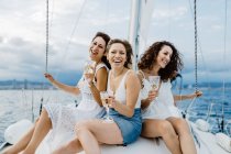 Cheerful friend with wine having fun on yacht — Stock Photo