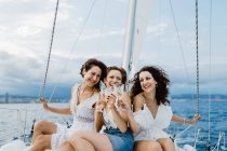 Веселий друг з вином розважається на яхті — стокове фото