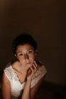 Sensuale donna seduta in camera oscura — Foto stock
