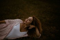 Femme dormant sur l'herbe dans la campagne — Photo de stock