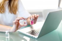 Feminino trabalhando no laptop com frascos médicos — Fotografia de Stock
