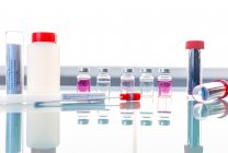 Tubes stériles et échantillons médicaux sur table en verre — Photo de stock