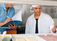 Colleagues checking food quality in canteen — Stock Photo