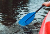 Cropped of person hand holding paddle while canoeing on river water — Stock Photo