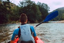 Вид сзади на юную спортсменку в красном каноэ на реке Селла в Испании — стоковое фото